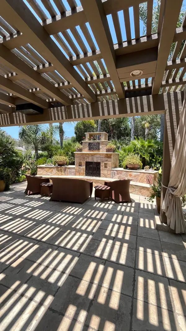 A pergola over a stone fireplace