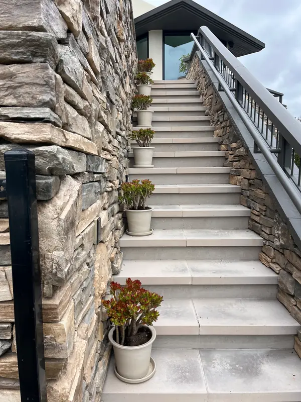 A stacked stone stair lined with pots